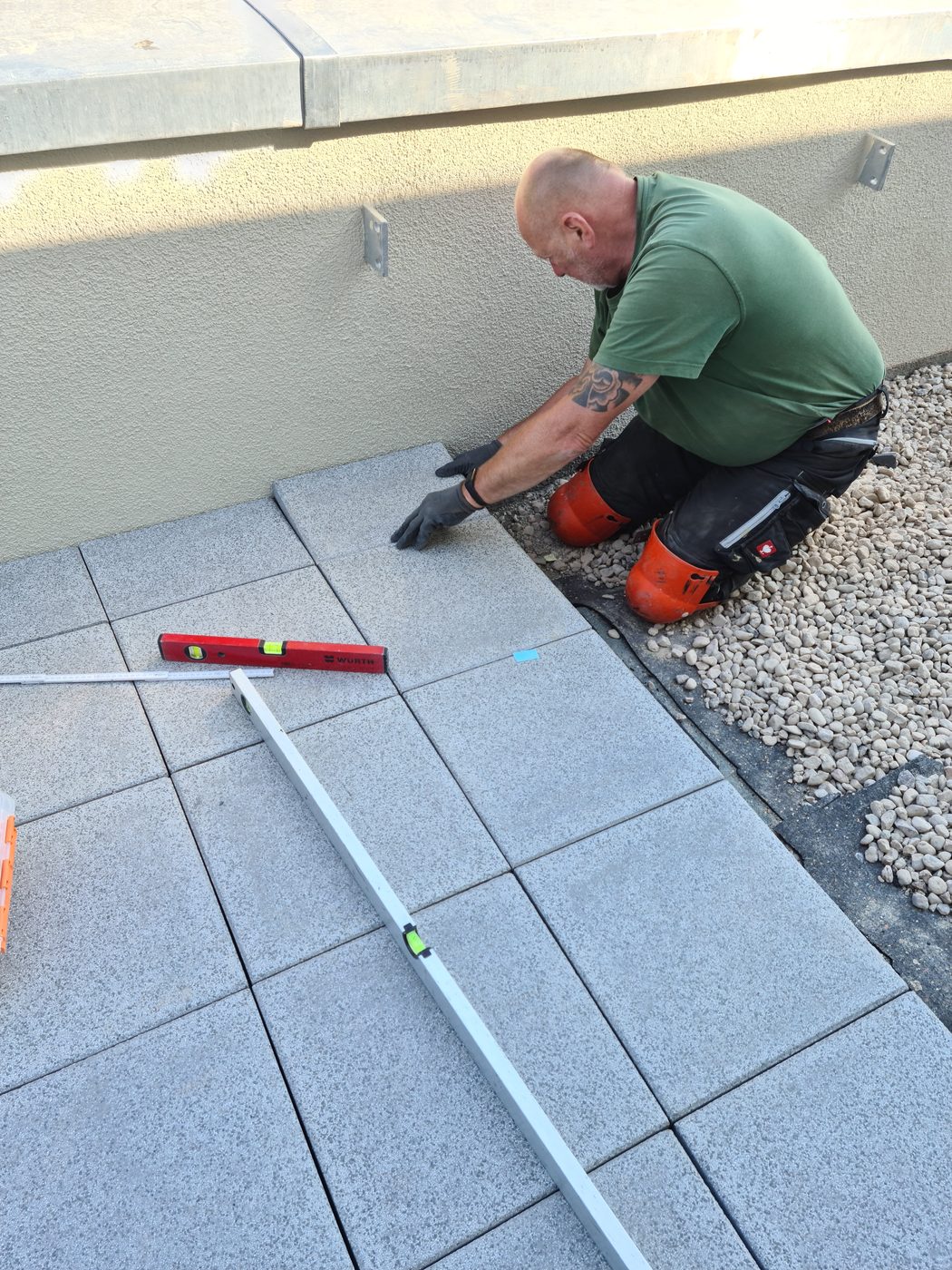 Dachdecker der Betoplan Dachbau verlegt Terrassenplatten auf einer abgedichteten Dachterrasse in Berlin