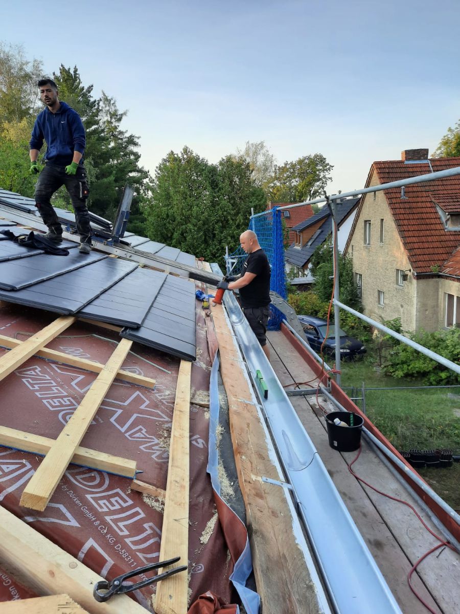 Zwei Betoplan-Dachdecker verlegen Unterspannbahn auf einem Steildach