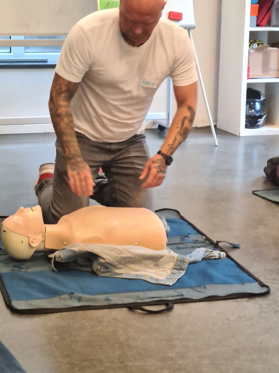 Betoplan-Mitarbeiter übt Herzdruckmassage an einer Puppe beim Ersthelferkurs